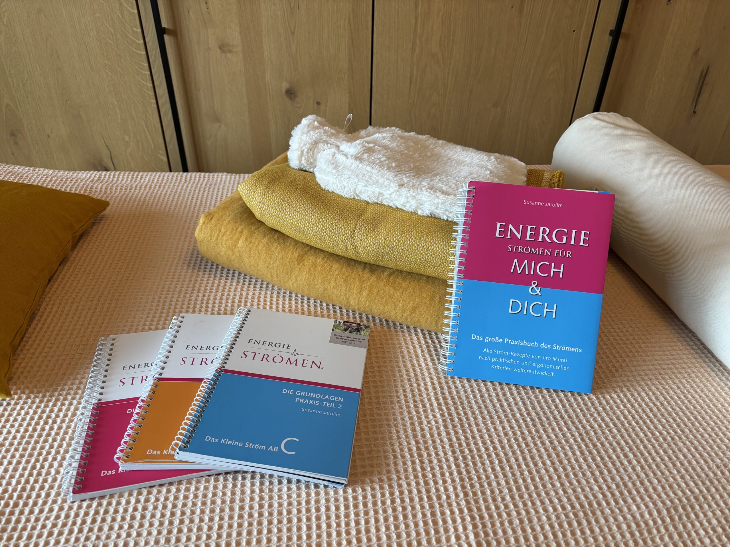 Ström-Bücher und Decken und Wärmeflasche auf der Massageliege in der Ström-Praxis