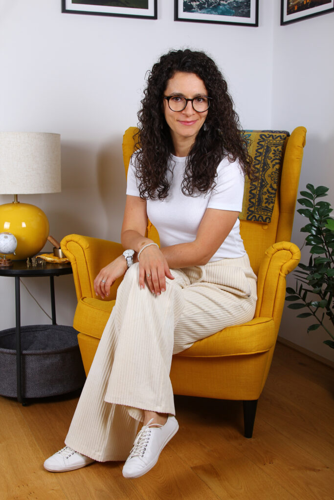 Portrait im Sitzen auf gelbem Ohrensessel von Barbara Weißensteiner sie ist Strömerin für Strömen, Energie-Strömen und Impuls-Strömen