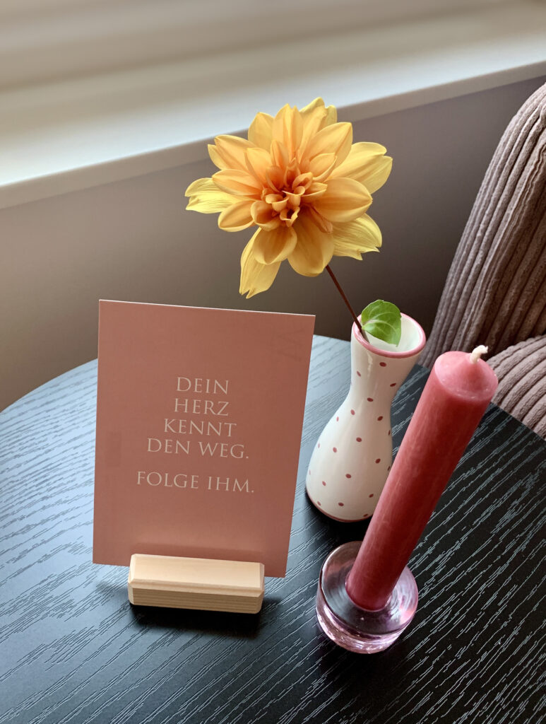 Postkarte mit Spruch und kleiner Vase mit gelber Blume und rosa Stabkerze